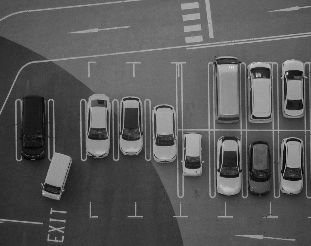 Cars parked in marked stalls on an asphalt parking lot.