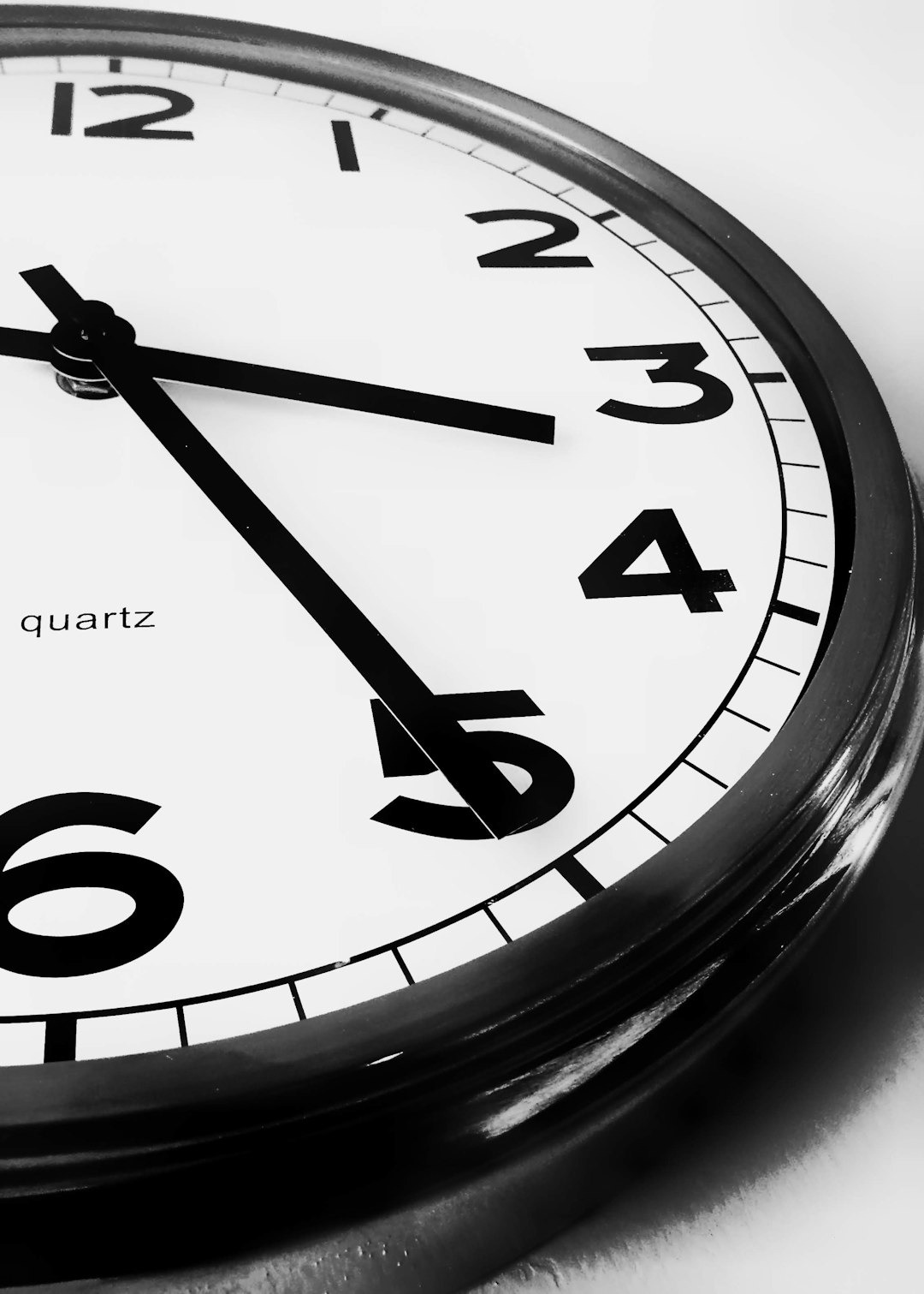 Wall clock face showing the time at ten twenty five.